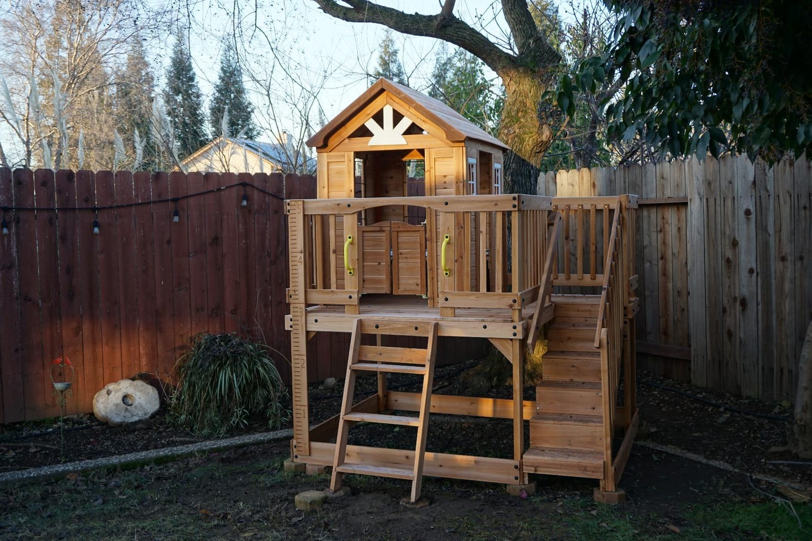 Backyard Discovery Scenic Heights Elevated Cedar Wooden Kids Playhouse with Play Kitchen, Wrap-Around Deck, Toy Storage Bench, Saloon-Style Doors, Ladder, Stairs, and Growth Chart for Outdoor Play customer photo 1